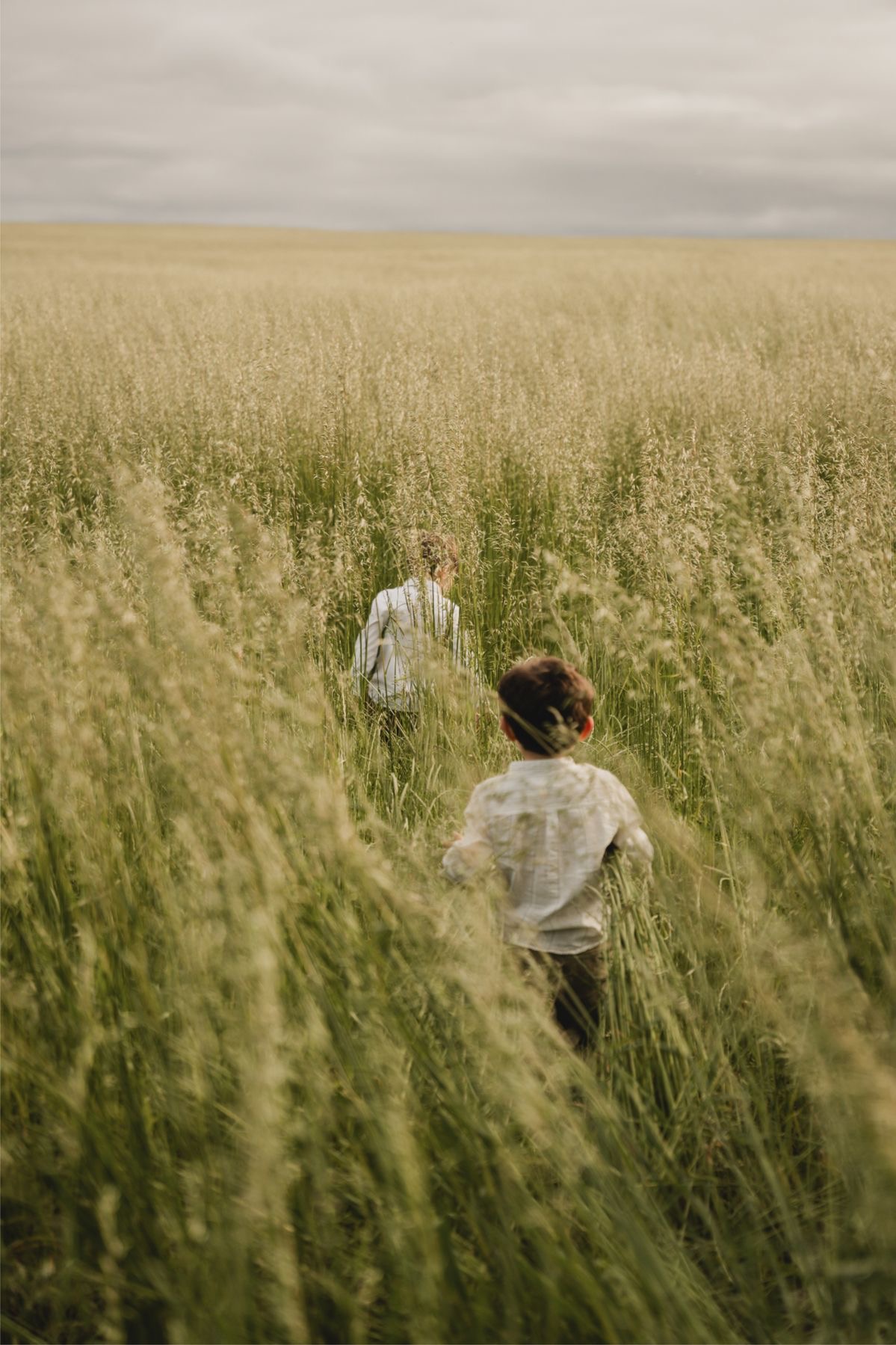 Kids running barefoot through tall grass